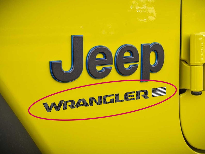 May include: Yellow Jeep Wrangler emblem with black and blue lettering. The word "Jeep" is above "Wrangler", which includes an American flag graphic. The emblem is on a yellow vehicle panel.