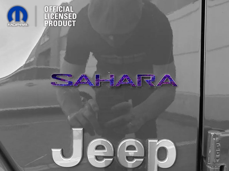 Pu&ograve; includere: Un'immagine in bianco e nero di una Jeep Sahara con un emblema "Sahara" viola e nero sul retro. La Jeep &egrave; un prodotto ufficiale con licenza.