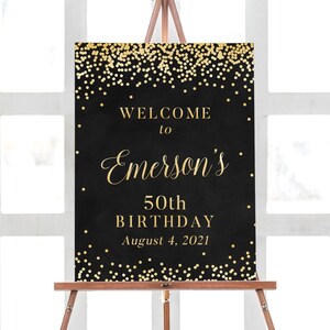 May include: Black and gold welcome sign with gold confetti. The sign reads "Welcome to Emerson's 50th Birthday August 4, 2021".