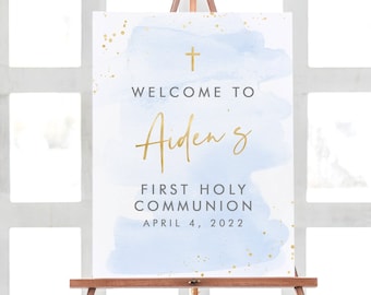 May include: A blue and gold watercolour welcome sign for a First Holy Communion. The sign says "Welcome to Aiden's First Holy Communion April 4, 2022".