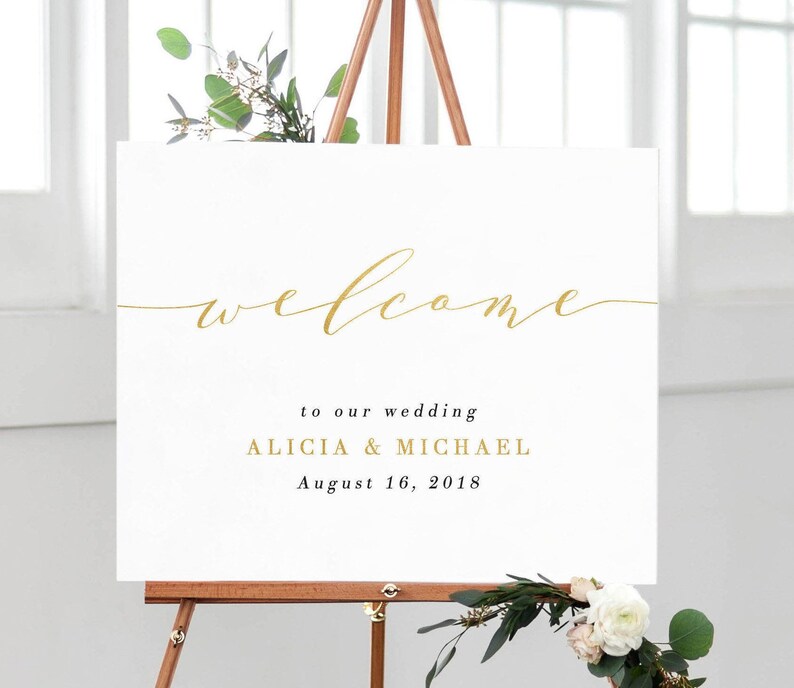 May include: White wedding welcome sign with gold calligraphy lettering that reads "welcome to our wedding Alicia & Michael August 16, 2018".