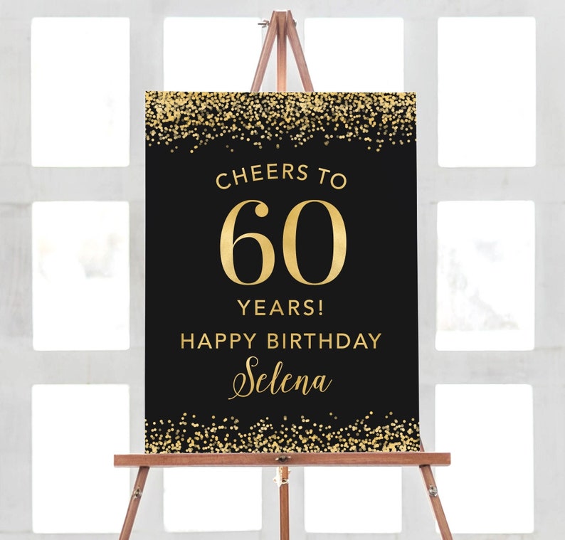 May include: Black and gold birthday sign with gold glitter confetti. The sign says "Cheers to 60 Years! Happy Birthday Selena".