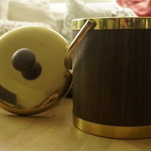 May include: A white ceramic mug with a black handle and the text "But First, Coffee" in a black, handwritten-style font. The mug is on a white surface.