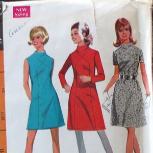 May include: Vintage McCall's sewing pattern 9426 featuring three dress designs. The pattern envelope shows illustrations of the dresses in teal, red, and patterned fabric. The envelope is orange and has text including "New Sizing" and "Misses' Dress in Three Versions."