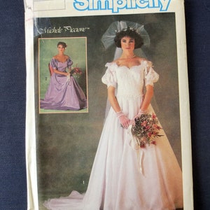 May include: A vintage Simplicity sewing pattern featuring a wedding dress design. The pattern envelope displays a photo of a bride in a white gown with a veil and bouquet. The design includes a long skirt and short sleeves.