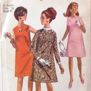 May include: Vintage Simplicity sewing pattern 7033 featuring three dress designs for junior petites. The pattern cover displays illustrations of the dresses in orange, floral print, and pink. Text includes "Jr. Petite Size 7jp Bust 32".
