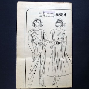 May include: A vintage sewing pattern featuring illustrations of two outfits: a jumpsuit and a dress. The pattern is labeled with sizes and a product number. The outfits are belted at the waist and have long sleeves.
