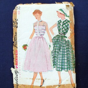 May include: Vintage Simplicity printed pattern 252 featuring illustrations of two dresses. One dress is pink with a sheer bodice and the other is green plaid. The pattern is for size 12, with a bust of 30 inches. The pattern is on a worn, aged paper.