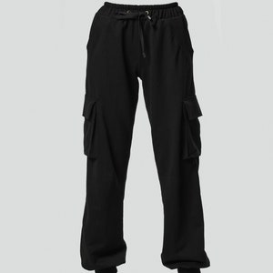 May include: Black cargo pants with a drawstring waist and two large pockets on each leg.