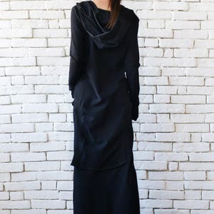 May include: A long black hooded dress with a long skirt and long sleeves. The dress is made of a soft, flowing fabric.