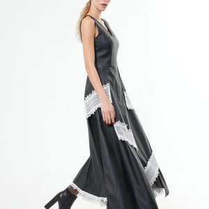 May include: A black maxi dress with a V-neckline and white lace trim. The dress has a fitted bodice and a flowing skirt.