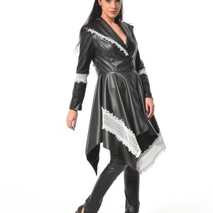 May include: A black leather jacket with white lace trim. The jacket has a long, asymmetrical hemline and a fitted silhouette.