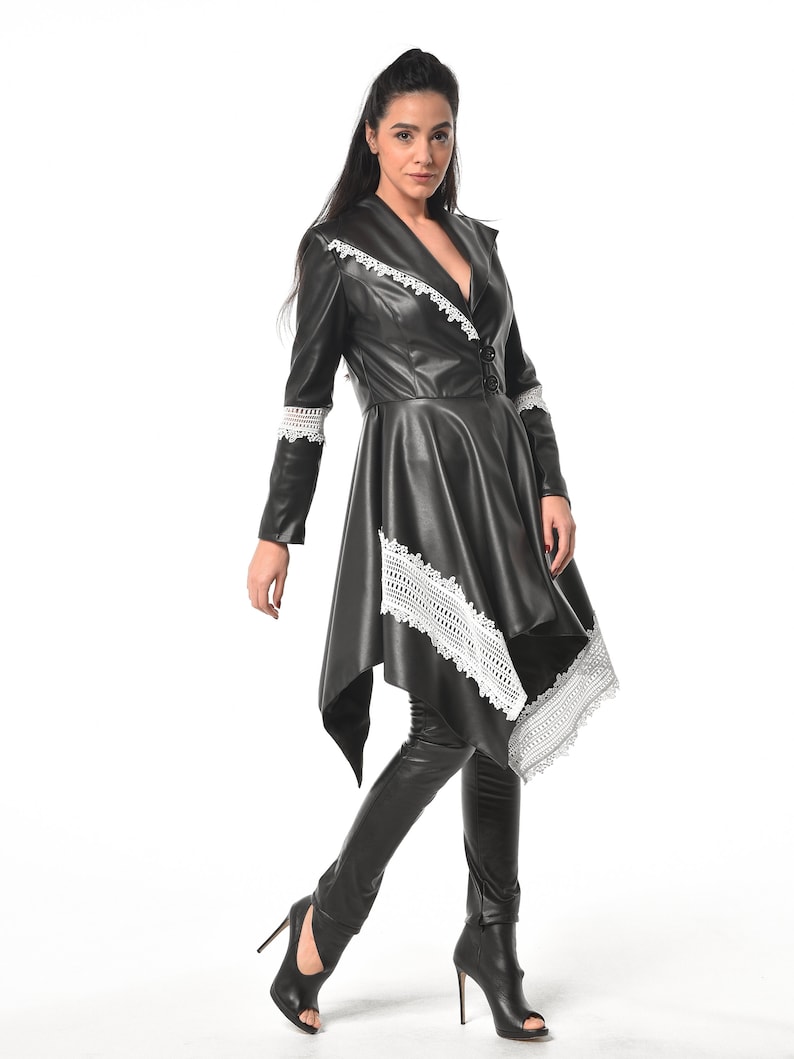 May include: A black leather jacket with white lace trim. The jacket has a long, asymmetrical hemline and a fitted silhouette.