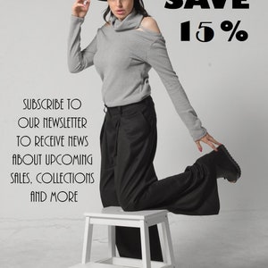 Puede incluir: Una mujer con un su&eacute;ter gris de cuello alto, pantalones negros y un sombrero negro est&aacute; de pie sobre un taburete blanco. El texto "SAVE 15%" est&aacute; en la esquina superior derecha de la imagen. El texto "SUBSCRIBE TO OUR NEWSLETTER TO RECEIVE NEWS ABOUT UPCOMING SALES, COLLECTIONS AND MORE" est&aacute; en la esquina inferior izquierda de la imagen. El texto "YOU CAN FIND THE LINK IN THE DESCRIPTION." est&aacute; en el centro inferior de la imagen.