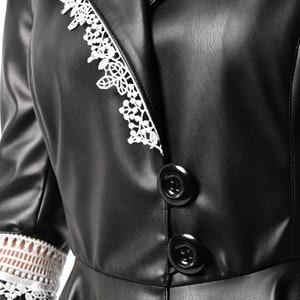 May include: Black faux leather jacket with white lace trim on the collar and sleeves. The jacket has a button closure and a fitted silhouette.
