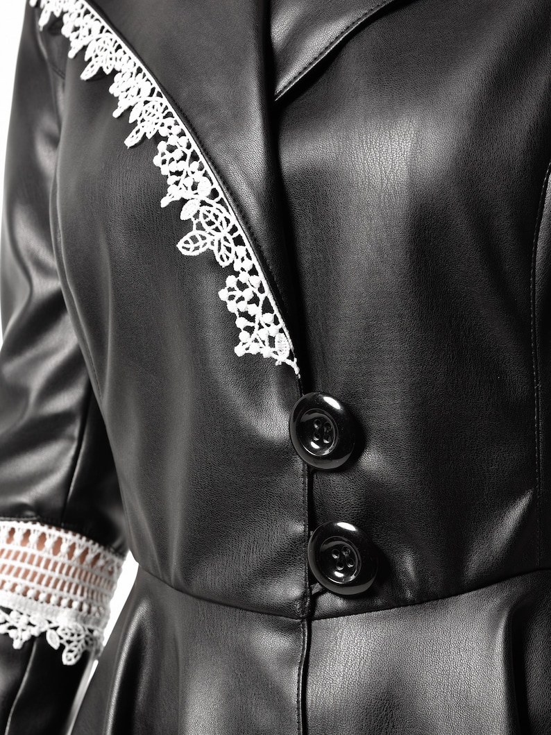May include: Black faux leather jacket with white lace trim on the collar and sleeves. The jacket has a button closure and a fitted silhouette.