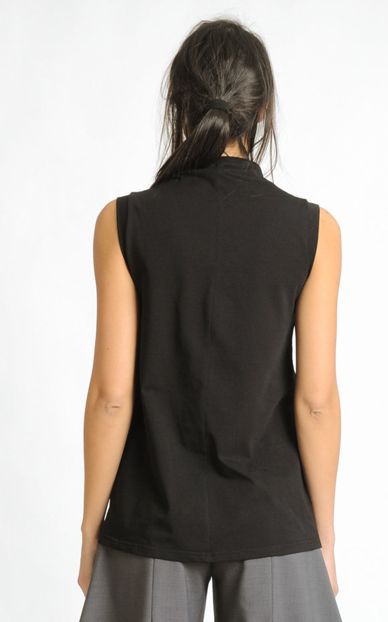May include: A black sleeveless mock neck shirt.