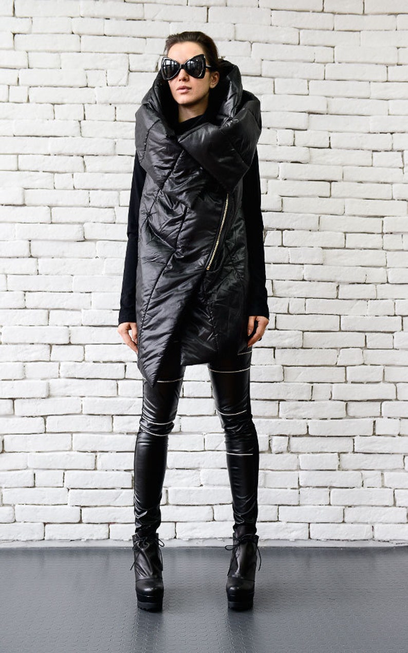 May include: A black quilted jacket with a large, folded collar and a zipper closure. The jacket is worn over black leggings and black heeled boots.
