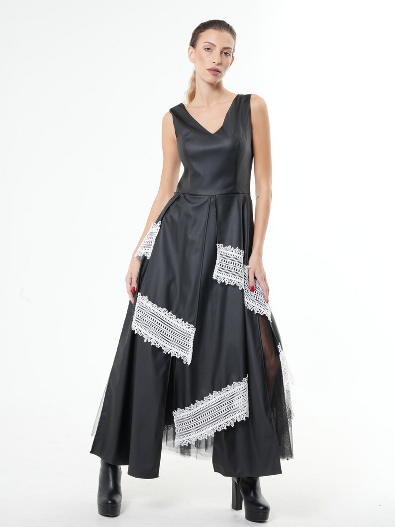 May include: A black maxi dress with a V-neckline and white lace detailing. The dress has a fitted bodice and a flowing skirt.