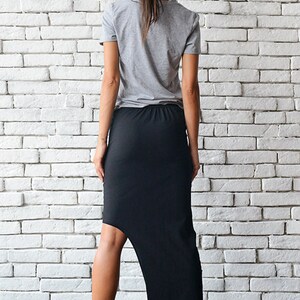 May include: A black asymmetrical skirt with a high-low hemline. The skirt is made of a stretchy, comfortable fabric and is perfect for a casual or dressy look.