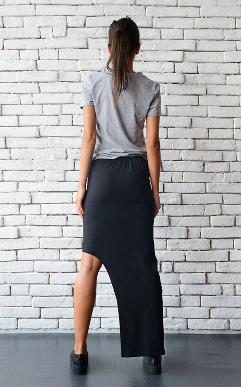May include: A black asymmetrical skirt with a high-low hemline. The skirt is made of a stretchy, comfortable fabric and is perfect for a casual or dressy look.