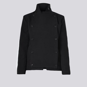 May include: A black jacket with a high collar and a double-breasted design. The jacket features six visible buttons and a tailored fit. The sleeves are long, and the fabric appears to be a textured wool blend.