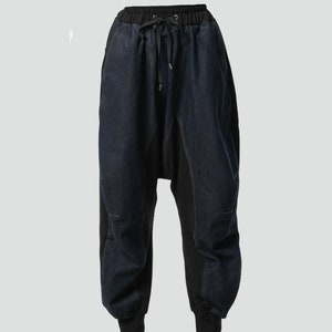 May include: Black and blue denim pants with a drawstring waist and a unique, asymmetrical design.
