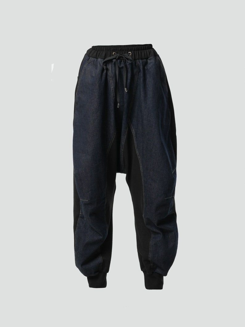 May include: Black and blue denim pants with a drawstring waist and a unique, asymmetrical design.