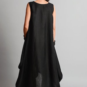 May include: A black sleeveless linen dress with a flowing, asymmetrical hemline. The dress is loose-fitting and has a relaxed, casual style.