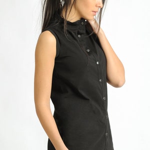 May include: A black sleeveless shirt with a mock neck and button closure. The shirt has a relaxed fit and is made of a soft, comfortable fabric.