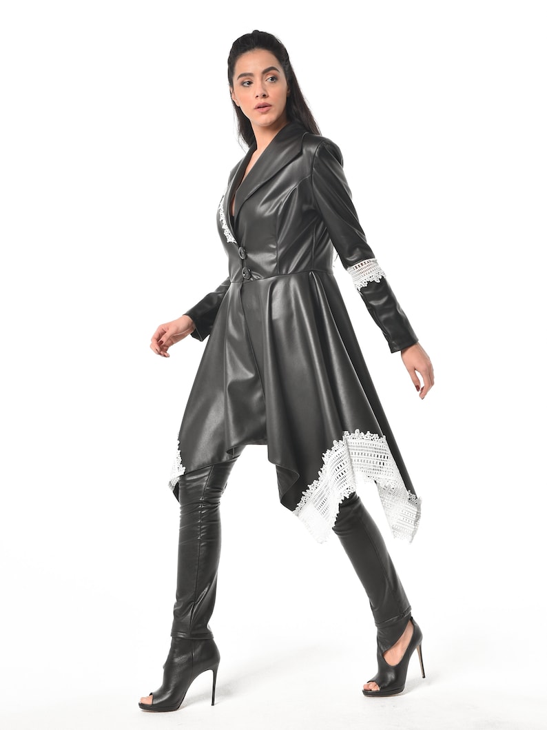 May include: A black leather jacket with a white lace trim. The jacket has a long, asymmetrical hemline and a fitted silhouette.