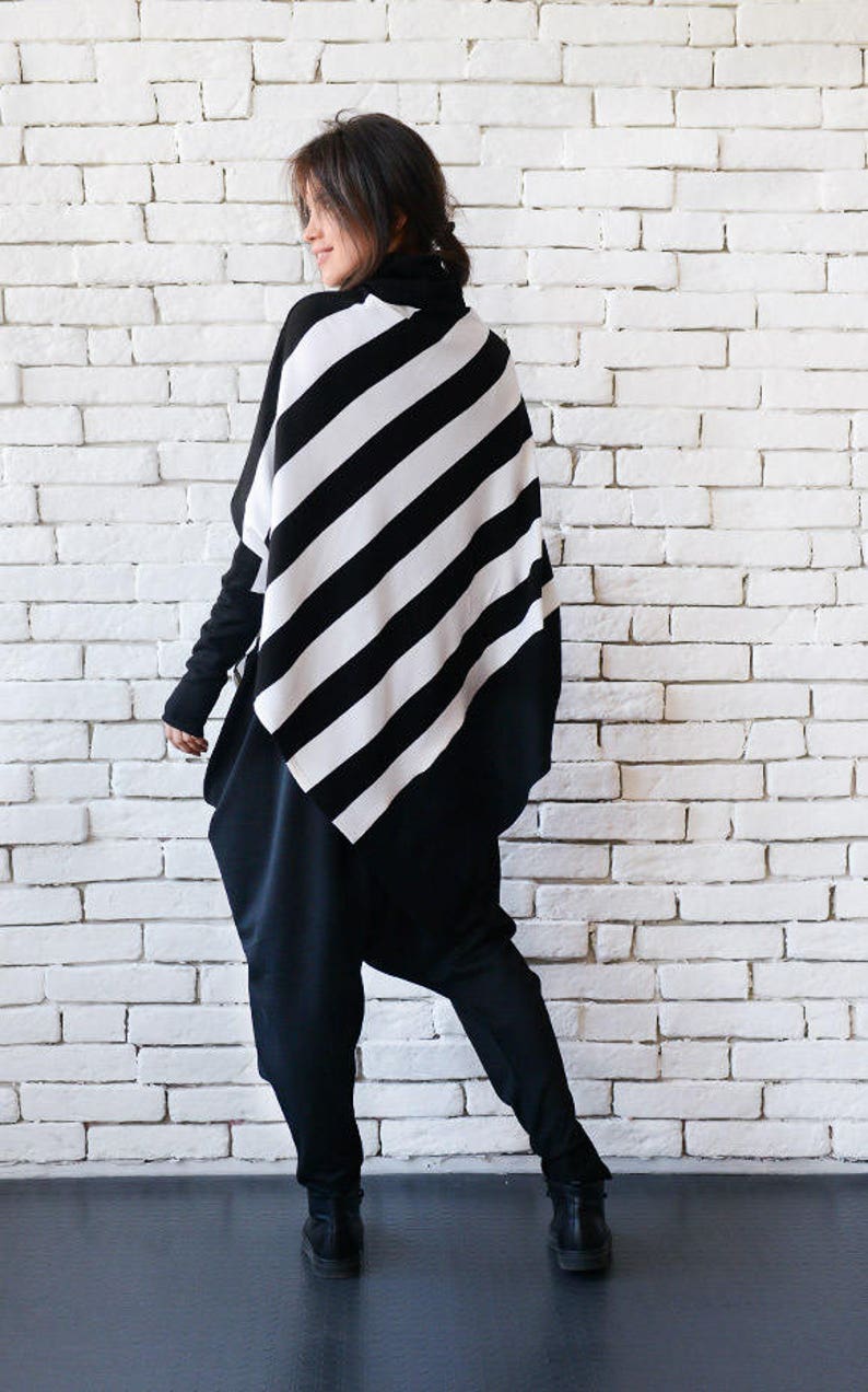 May include: A black and white striped tunic with a diagonal pattern. The tunic is worn over black pants.