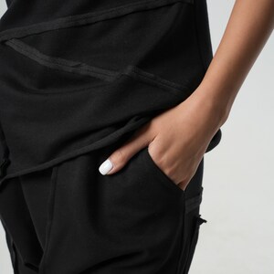 May include: Black pants with a pocket and a black top with a layered design.
