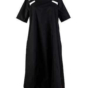 May include: A black midi dress with cutouts at the shoulders and a loose, flowing silhouette.