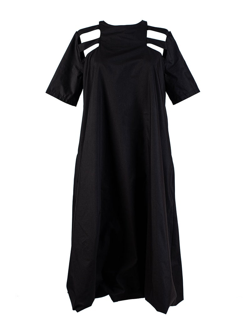 May include: A black midi dress with cutouts at the shoulders and a loose, flowing silhouette.