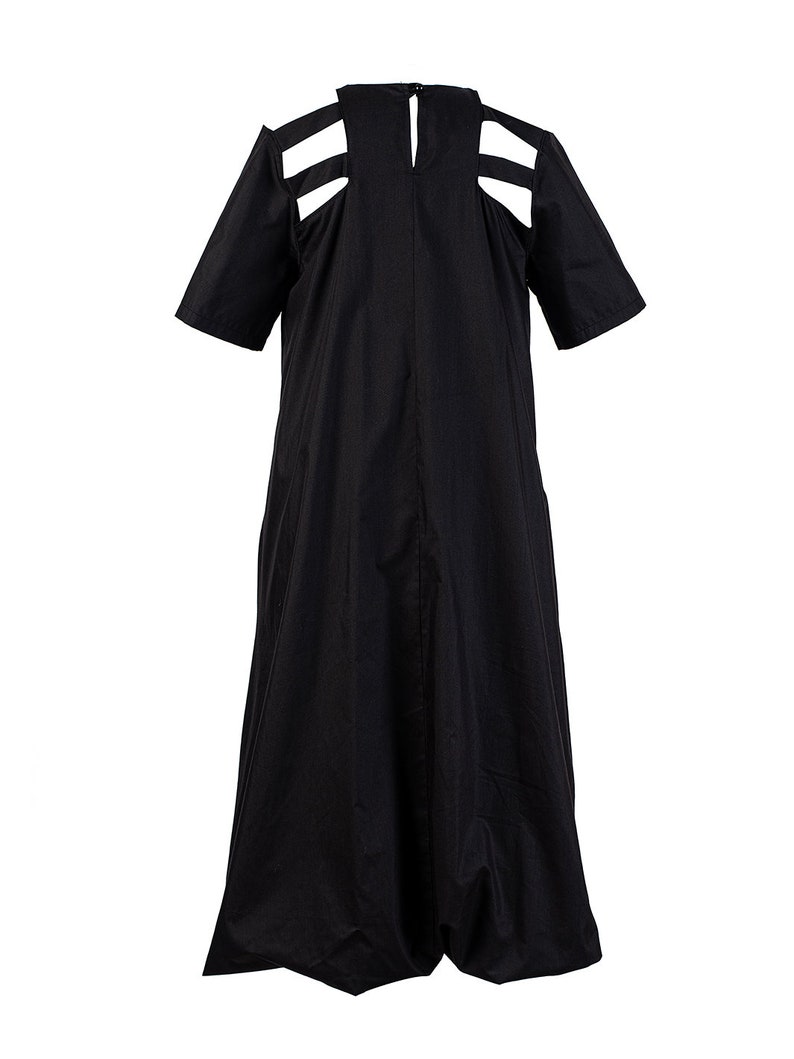 May include: A black midi dress with cutouts at the shoulders and a gathered skirt.