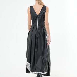 May include: A black sleeveless maxi dress with a white lace trim at the hem. The dress has a back zipper and a V-neckline.
