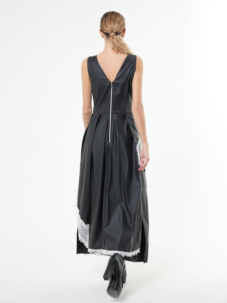 May include: A black sleeveless maxi dress with a white lace trim at the hem. The dress has a back zipper and a V-neckline.