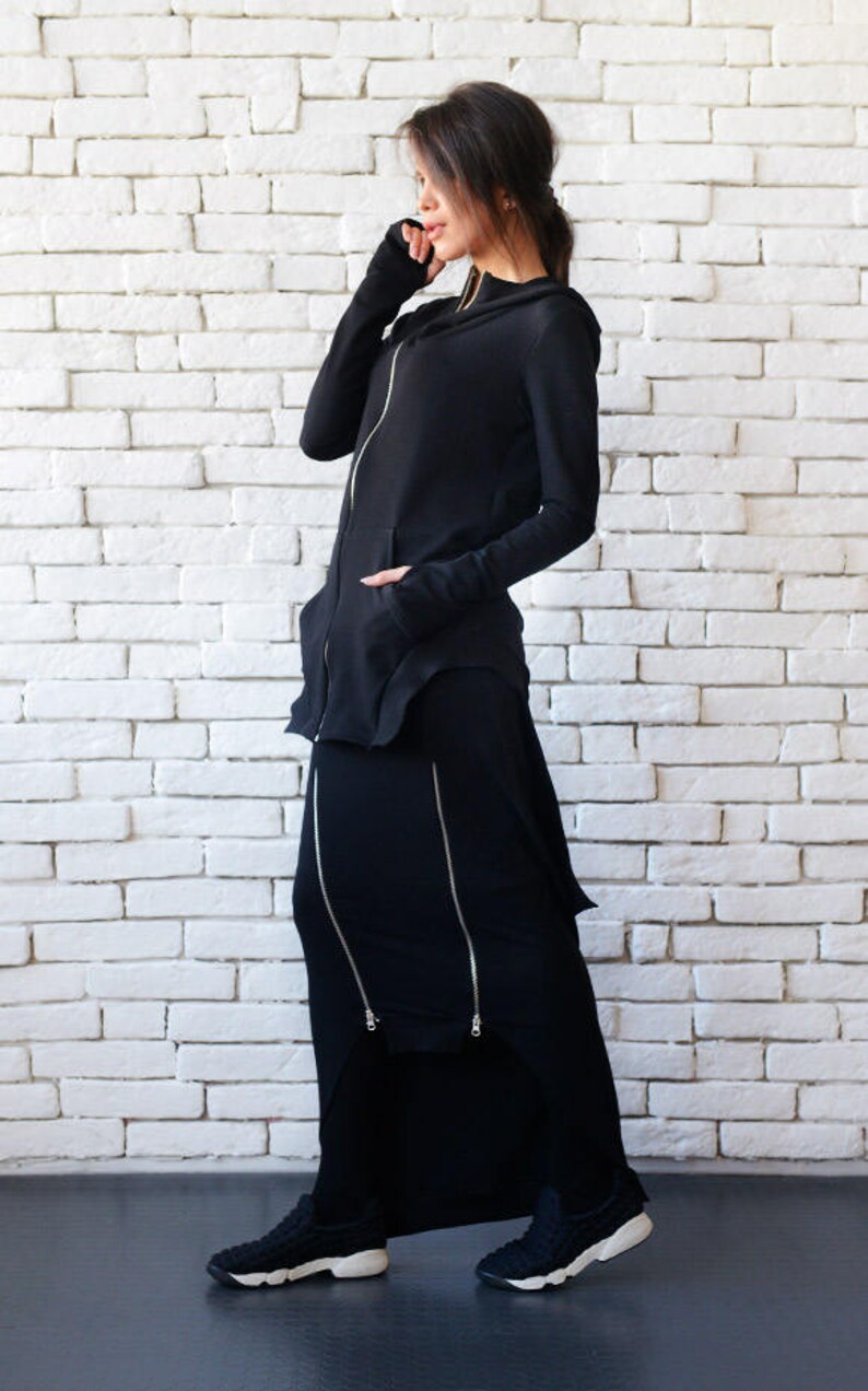 May include: A black hooded sweatshirt with a zipper and a black maxi skirt with multiple zippers. The skirt has a slight A-line shape and the sweatshirt has a long, flowing design.