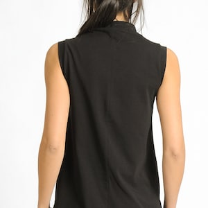 May include: A black sleeveless shirt with a mock neck.