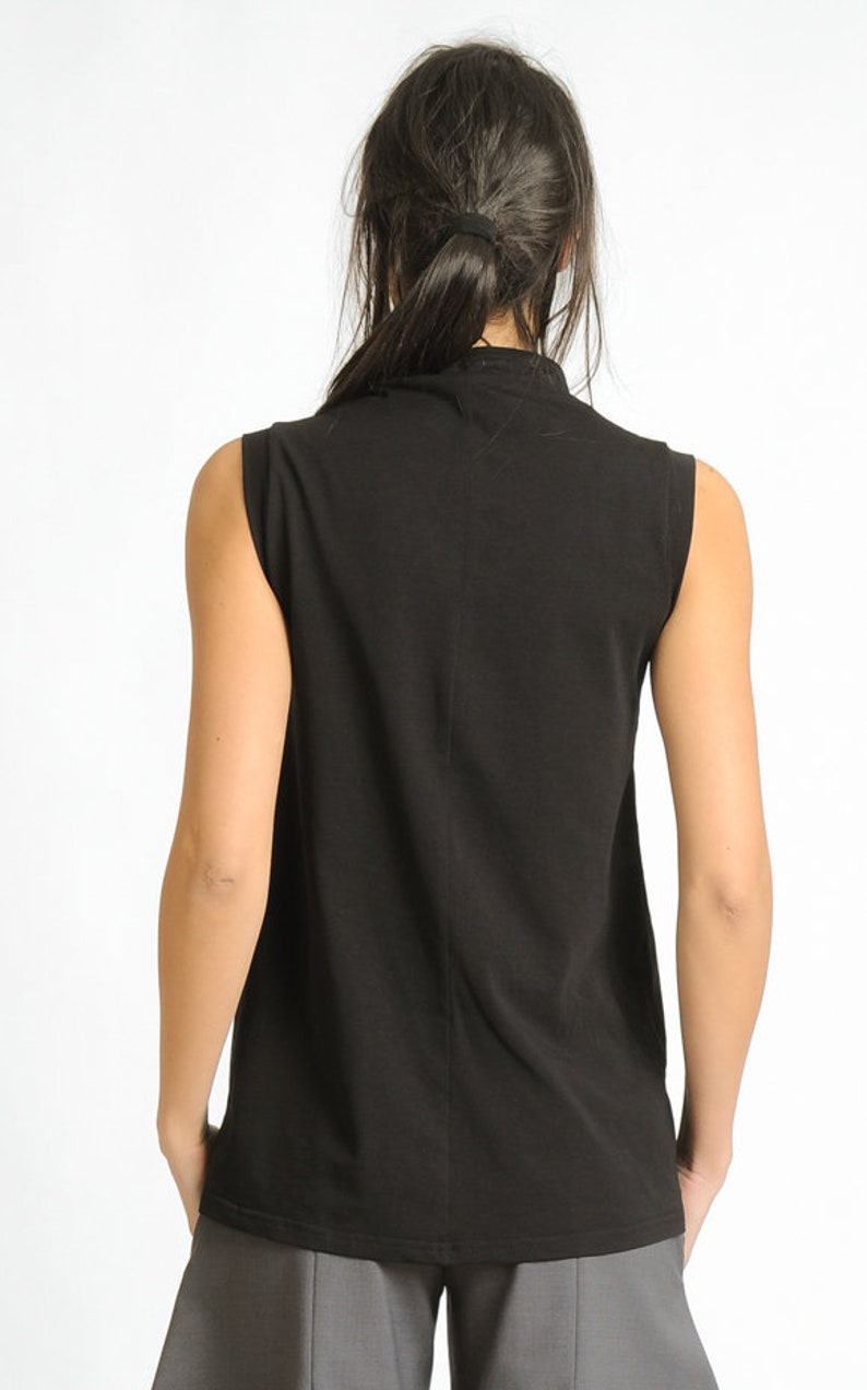 May include: A black sleeveless shirt with a mock neck.