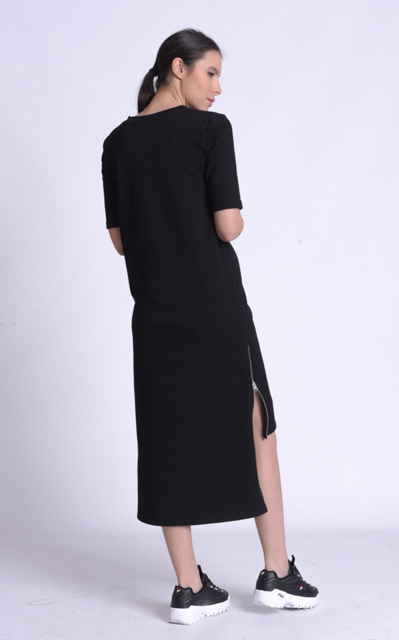 Puede incluir: Un vestido midi negro con un detalle de cremallera lateral. El vestido est&aacute; hecho de una tela suave y c&oacute;moda y tiene un ajuste holgado.