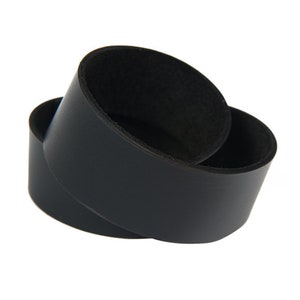 May include: Two black leather cup coasters, one stacked on top of the other.
