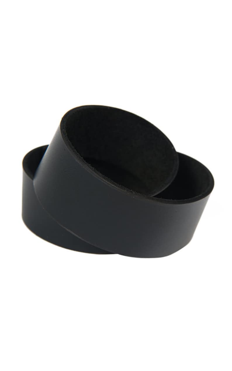 May include: Two black leather cup coasters, one stacked on top of the other.