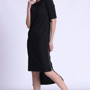 Puede incluir: Un vestido midi negro con cremallera lateral y bajo asim&eacute;trico. El vestido est&aacute; hecho de una tela suave y c&oacute;moda y es perfecto para el uso diario.