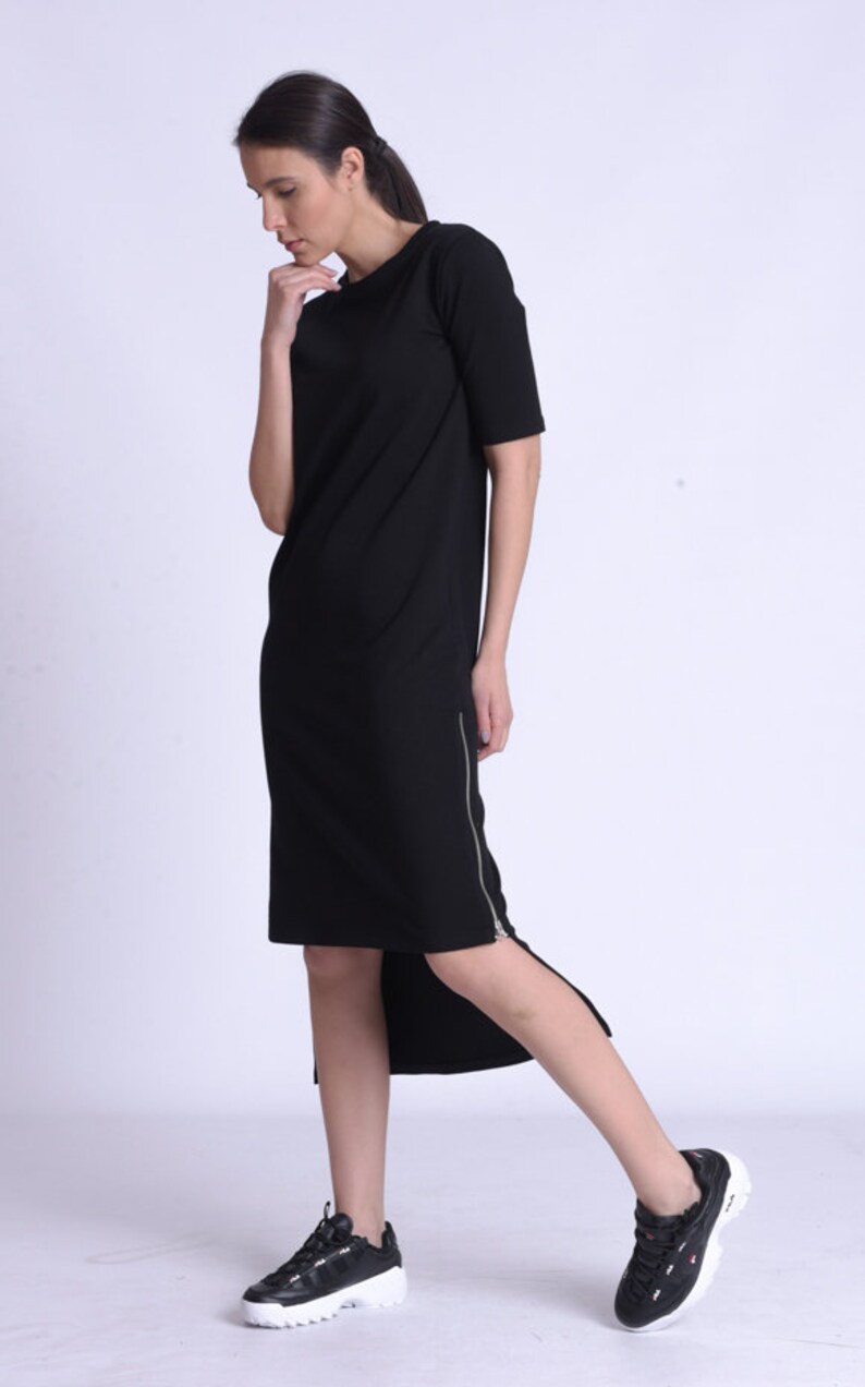 Puede incluir: Un vestido midi negro con cremallera lateral y bajo asim&eacute;trico. El vestido est&aacute; hecho de una tela suave y c&oacute;moda y es perfecto para el uso diario.