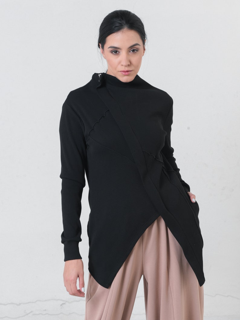 May include: A black long-sleeved shirt with a high neckline and a diagonal seam detail. The shirt is made of a soft, stretchy fabric and has a relaxed fit.