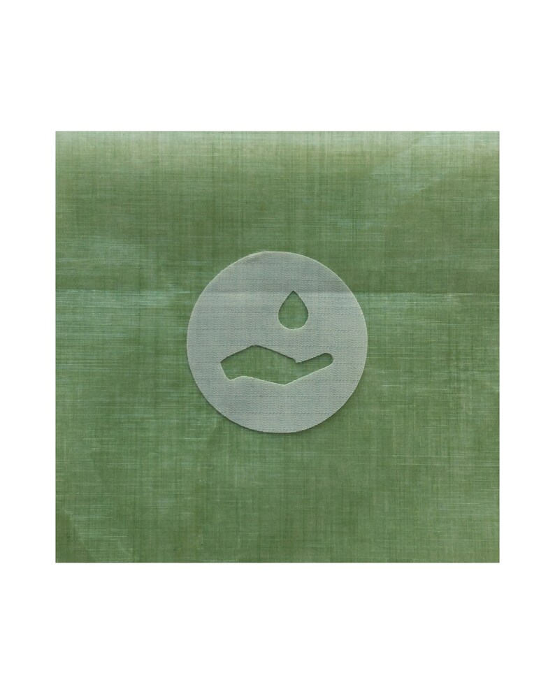 May include: A green fabric with a white circle containing a hand with a water drop above it. The fabric has a subtle texture.
