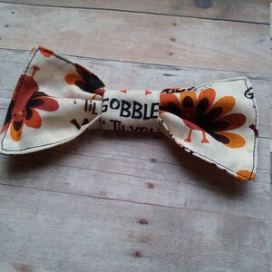 May include: A white bow tie with a brown and orange turkey print and the text "Til Gobble Til You"