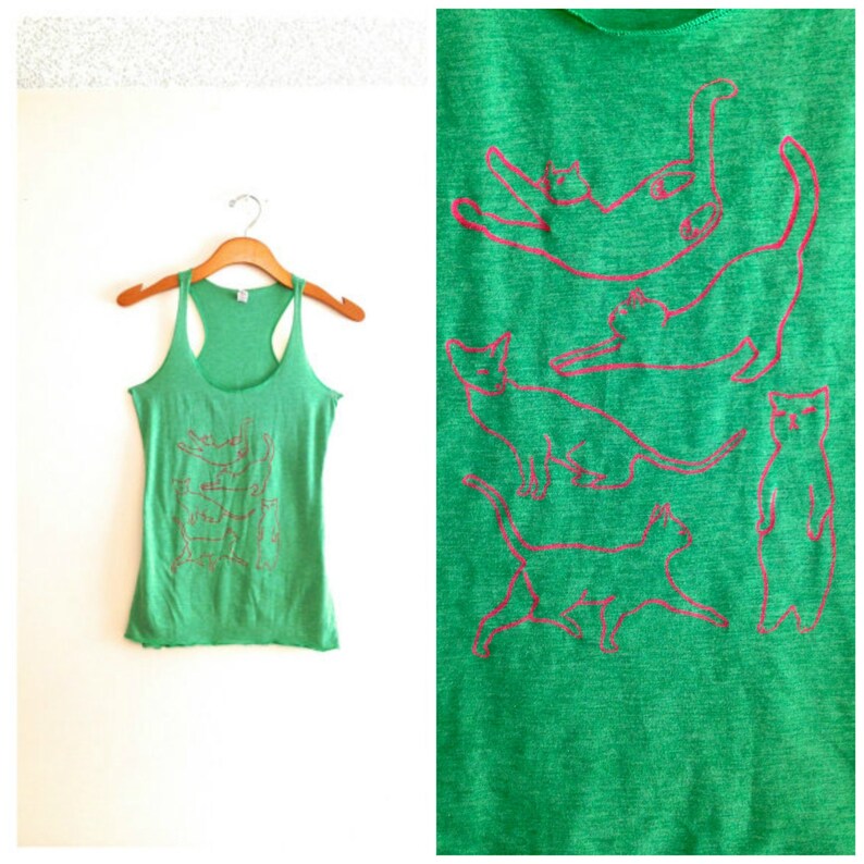 May include: Green tank top with a pink outline of multiple cats in different poses. The tank top is made of a soft, comfortable material.
